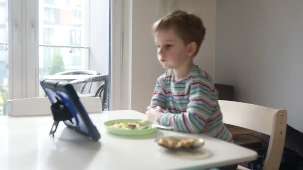 Ein Kleiner Junge Sitzt Einem Esstisch Und Beobachtet Aufmerksam Einen — Stockvideo
