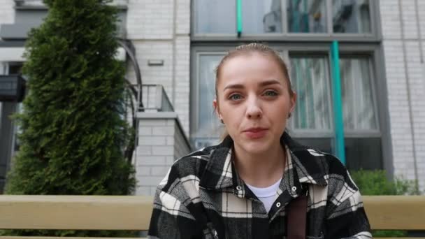 Young Woman Her Hair Tied Back Wearing Plaid Jacket Sits — Stock Video
