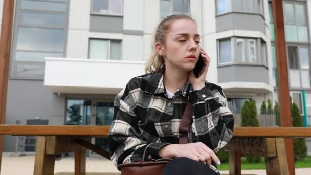 Bir Telefon Görüşmesi Yaparken Bankta Oturan Bir Kadın Cep Telefonuyla — Stok video