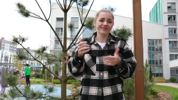 Une Jeune Femme Tient Dans Parc Urbain Avec Des Bâtiments — Video