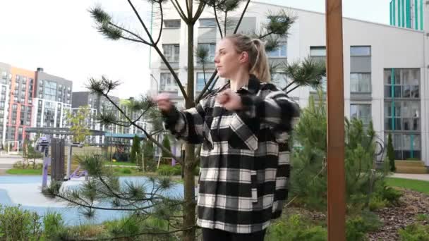 Молода Жінка Бере Участь Розтяжній Рутині Серед Зелені Міського Парку — стокове відео