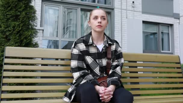 Μια Νεαρή Γυναίκα Γαλάζια Μαλλιά Κάθεται Ένα Ξύλινο Παγκάκι Του — Αρχείο Βίντεο
