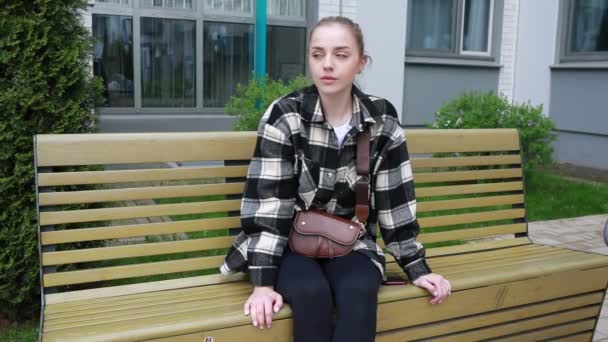 Молода Жінка Одягнена Повсякденну Сорочку Плечовою Сумкою Задумливо Сидить Лавці — стокове відео
