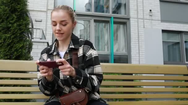 Een Jonge Vrouw Beslag Genomen Door Haar Smartphone Terwijl Een — Stockvideo
