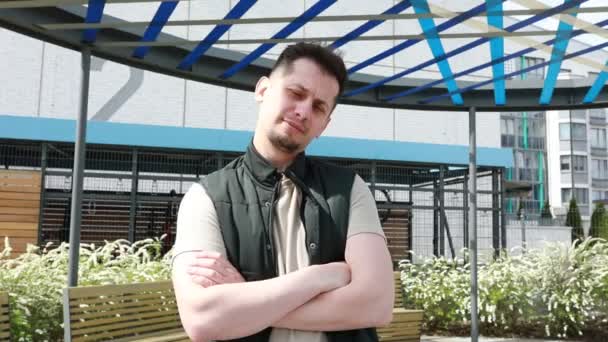 Kolları Çapraz Bir Şekilde Bankın Önünde Duran Bir Adam Görülüyor — Stok video