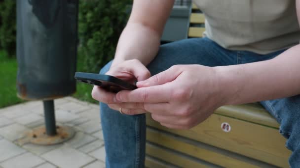 Člověk Sedí Lavičce Zabraný Mobilu Poklepávají Obrazovku Posouvají Občas Odmlčí — Stock video