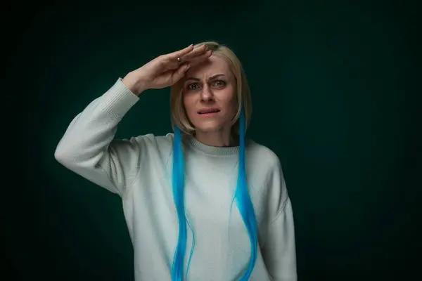 stock image A woman is depicted wearing a white sweater with a blue ribbon around her neck. She appears poised and elegant in her attire.