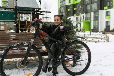Kışın bisiklet süren genç ve güzel bir kadın..
