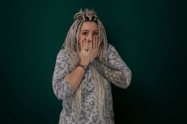 Bir kadın elleriyle yüzünü kapatıyor, muhtemelen üzüntü, üzüntü ya da utanç belirtisi. Elleri yanaklarına bastırılmış, gözlerini ve ifadesini gizliyor..