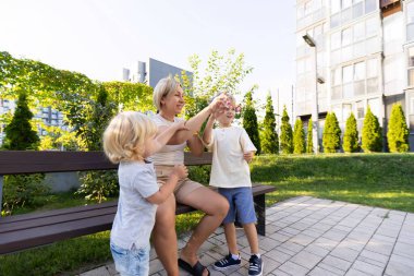 Bir anne güneşli bir öğleden sonra oyun sahasında birlikte oynayan iki oğluyla neşeyle meşgul olur. Çocuklar gülüyor ve eğleniyorlar. Mutlulukla dolu keyifli bir atmosfer yaratıyorlar.