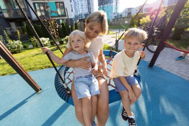 Bir anne, iki oğluyla birlikte salıncakta oturup neşeli anları canlı bir oyun parkında paylaşır. Yeşillik ve modern binalarla çevriliyken neşeli sohbetlere dalarlar. Parlak