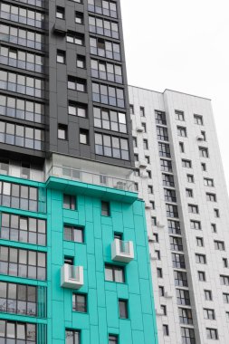 Resimde, konut ve konut sigortası seçeneklerinin yanı sıra kira ve ipotek olanaklarını da vurgulayan çağdaş yüksek katlı apartmanlar yer alıyor..