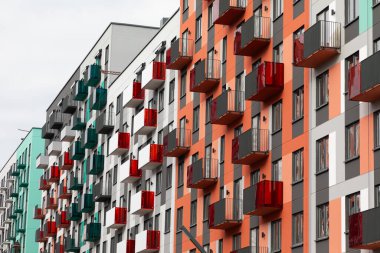 Colorful high-rise apartment buildings line a residential area, with distinct balconies creating a lively atmosphere. This setting reflects contemporary urban life and housing options. clipart