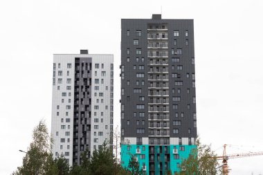 Çağdaş mimari ve kentsel yaşamın özünü vurgulayan iki yüksek katlı apartman yan yana duruyor..