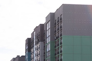 Konut kredisi, ipotek ve emlak sigortası gereksinimlerini vurgulayan manzarada, hareketli bir yerleşim bölgesinde çağdaş yüksek katlı apartmanlar sergileniyor.