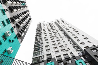 Bir yerleşim bölgesinde iki uzun, çağdaş apartman yükselerek, kentsel yaşam seçeneklerini ve potansiyel kiracılar için mevcut konut olanaklarını vurguluyor.