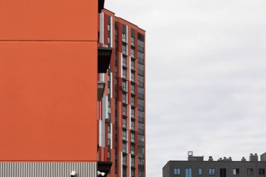 Ufuk çizgisinde, konut ve emlak sigortası seçeneklerindeki kentsel kalkınma eğilimlerini yansıtan, yerleşim bölgesine yerleştirilmiş modern yüksek katlı apartmanlar yer alıyor..