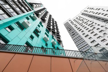 Bakış açısı, bir yerleşim yerindeki yüksek katlı apartmanları yakalıyor ve modern mimariyi ve kira ve ipotekli yaşam düzenlemelerini ön plana çıkarıyor..