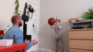 Bir baba ve oğlu, çocukların doğum günlerini neşeyle kutluyor. Oyunların, kahkahaların ve lezzetli pastaların tadını çıkarıyorlar. Oturma odalarında süslemelerle dolu..