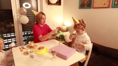Bir annenin iki oğlunu yaratıcı aktivitelere dahil ettiği evde neşeli bir doğum günü kutlaması gerçekleşir. Kahkahalarla lezzetli atıştırmalıkları paylaşıyorlar..