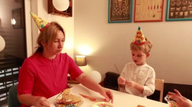 Neşeli bir doğum günü kutlaması anne pastadan zevk alırken iki küçük oğlu eğlenceli aktivitelere girişiyor ve evde birlikte güzel anılar yaratıyorlar..