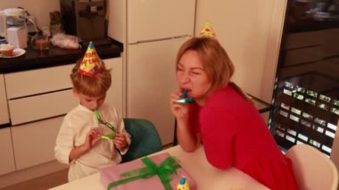 Sıcak bir mutfakta, bir anne ve iki oğlu doğum gününü kahkahalar ve şenliklerle kutluyorlar. Parti şapkaları, şenlikli etkinliklerden zevk alırken kafalarını süsleyip neşeli anılar yaratıyor..