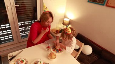 Neşeli kutlamada bir anne ve iki oğlu pasta ve oyun oynuyorlar. Birlikte kalıcı anılar yaratırken parti şapkaları takıyorlar, kahkaha ve aşkla dolu..