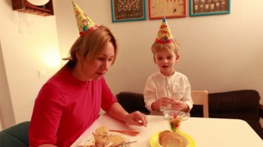 Bir anne doğum gününü iki oğluyla birlikte kutlar. Lezzetli pastadan ve evlerinde ikram edilmekten zevk alır. Bu özel anda aile gülücükleri ve kahkahaları paylaşıyor..