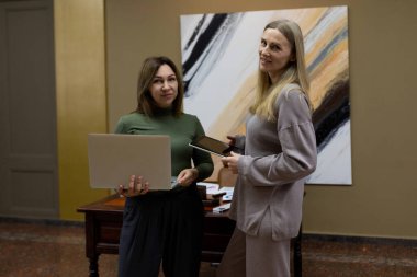 Modern bir ofiste iki kadın hararetli bir tartışmaya girişiyor. Biri dizüstü bilgisayar, diğeri tablet. Beyin fırtınası yapmak için malzemelerle çevrili. Çevre sıcak ve davetkar..