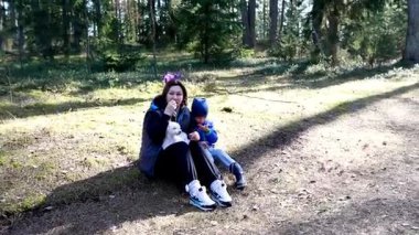 Bir aile ormanda birlikte vakit geçirir, bir çocuk güler ve bir köpek yavrusuyla oynar. Doğayla çevrili güneşli kış havasının tadını çıkarırken atmosfer çok neşeli..