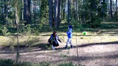 Bir anne ve oğlu güneşli bir orman yolunu keşfediyorlar. Anne yerdeki bir şeyi incelemek için çömelir. Oğul ise yakınlarda yürüyüp doğal ortamın tadını çıkarır..