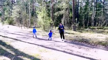 Bir aile ormanda neşeli bir öğleden sonra geçirir, çocukların neşeli bir şekilde çamurlu bir yolda koştuğu, sıcak güneş ışığı ve doğal güzelliklerle kucaklandığı bir yerde..