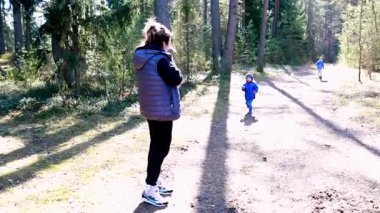 Huzurlu bir ormanda, bir anne iki çocuğunu oynarken izler. Güneş ışığı ağaçların arasından süzülür ve dışarıda eğlenceli ve aktif bir günün tadını çıkarırlar. Atmosfer neşeli ve huzurlu..