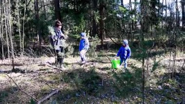 İki çocuk çevrelerini keşfederken ormanda eğlenceli bir gezinti yapıyorlar. Bir bakıcı onlara açık havada doğayla nasıl kolayca etkileşim kurulacağını gösterir..