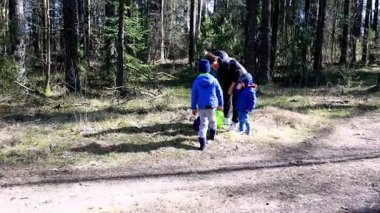 İki çocuk ormanı keşfederken bir ebeveyn onlara eğlenceli bir keşifte rehberlik ediyor. Sakin ortam ve güneşli hava onların açık hava maceralarını ve öğrenme deneyimlerini geliştirir..