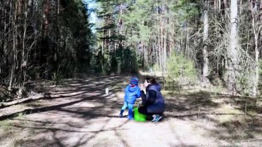 Bir anne ve küçük çocuğu ormanda bir günün tadını çıkarıyorlar. Ağaçlarla kaplı, barışçıl bir toprak yol keşfediyorlar. Etkileşimlerine ve doğanın güzelliğine odaklanıyorlar..