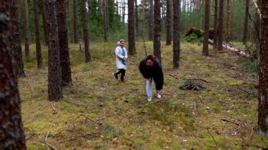 Baharın başlarında sakin bir ormanda gezinen iki birey. Sakin atmosfer yemyeşil yemyeşil ve etraflarındaki yüksek çam ağaçları ile güçlenir..