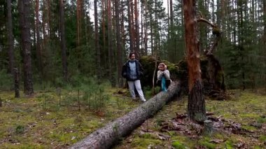 İki birey, bereketli yeşilliklerle çevrili bir ağacın gövdesinde sakin bir anın tadını çıkarırlar. Huzurlu atmosferi alırken doğayı kucaklarlar..