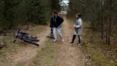 İki arkadaş kırsal bir patikada durmuş bisikletleri yerde yatarken durumu tartışıyorlar. Çevrelerindeki orman yemyeşil ama yine de kıştan uyanır..