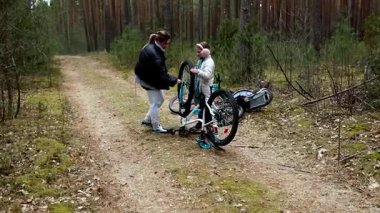 İki bisikletçi bir bisikleti tamir etmek için orman yolunda mola verir. Etrafları uzun ağaçlarla çevriliyken, etraflarındaki barışçıl doğanın tadını çıkarırken birlikte çalışırlar..
