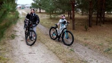Bir aile, ağaçlık bir alanda kirli bir patika boyunca bisiklet macerasına başlar. Bir yetişkin yolculuğa hazırlanırken iki çocuk sevinçle bisiklete biniyor. Doğa onları çevrelemiş..