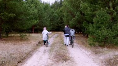 İki arkadaş yemyeşil ağaçlarla çevrili toprak bir yolda bisiklet sürüyorlar. Temiz havanın ve huzurlu sonbahar manzarasının tadını çıkarırken bir an kahkahalar atarlar..
