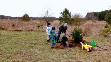 Kırsal bir ortamda, bir aile genç bir ağaç dikerek çocuklara doğayı ve sorumluluğu öğretir. Soğuk hava, açık havada öğrenmelerine bir neşe katıyor..