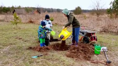 İki çocuk ve bir kadın aktif olarak çim tarlasında kazıyor ve ekiyorlar. Bahar havası, birlikte dışarıda vakit geçirmenin keyfini çıkardıkları neşeli sahneyi hazırlar..