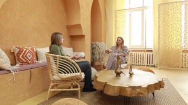 İki kadın sıcacık, sıcacık bir mekanda refah ve farkındalık kavrayışlarını paylaşıyor. Atmosfer rahatlama ve içgözlem sağlıyor, derin tartışmalar için mükemmel..