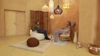 İki birey sıcak tonlarla ve davetkar dokularla dolu rahatlatıcı bir ortamda dostça sohbet ederler. Alan, doğal malzemeler ve hafif ışıklandırma üzerine odaklanmış..