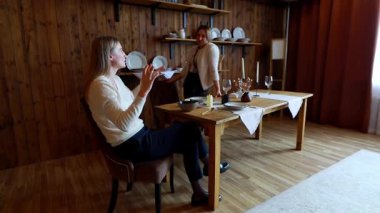 İki kadın güzel, ahşap bir masada otururken canlı bir tartışmayı paylaşıyor. Oda kırsal bir dekor ve sıcak bir ortam yaratıyor..