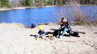 Bir aile, çocukların kumda oynadığı, oyuncaklarla inşa ettiği ve evcil bir köpeğin bölgeyi keşfettiği göl kenarında güneşli bir gün geçirir. Kahkaha ve neşe onlar rahatlarken havayı doldurur..