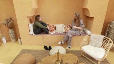 Kadınlar fikirlerini ve sezgilerini paylaşırken büyüleyici ve sıcak bir iç mekanda rahatça otururlar. Mekan rahat bir dekor ve anlamlı tartışmalar için ideal rahat bir atmosfer içeriyor..