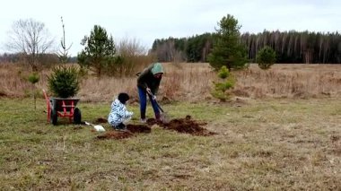 Katılımcılar soğuk bir günde kırsal bir bölgede ağaç dikme işine girerek, toplum ve çevresel sorumluluk duygusunu teşvik ediyorlar. Etkinlik çocukları doğayı takdir etmeye teşvik ediyor..